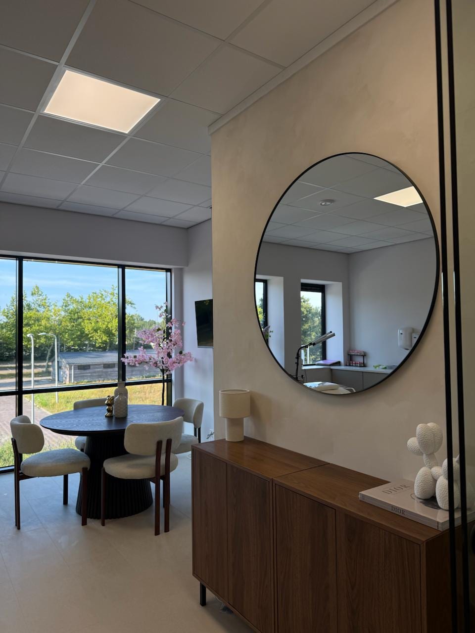 De salon met ronde spiegel en zithoek